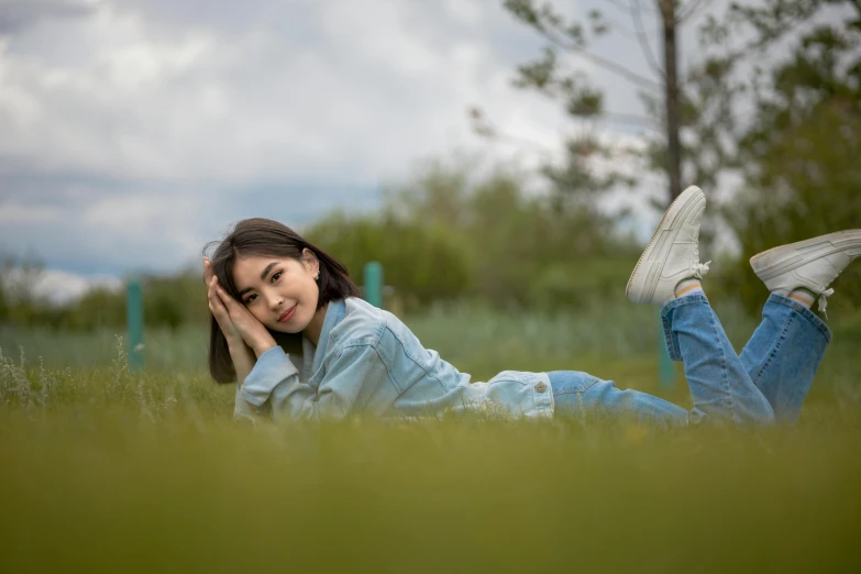 a girl laying on the ground with her hands behind her head