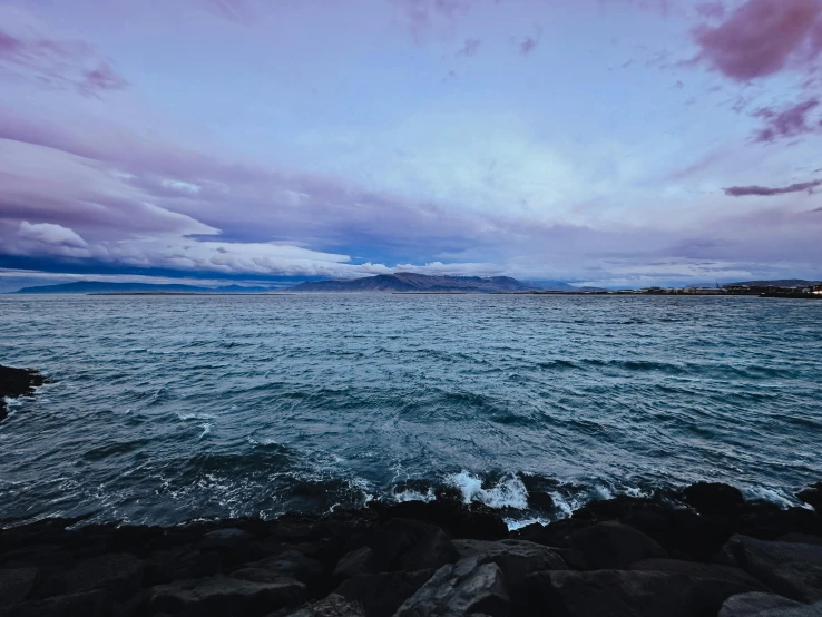 the water at dusk is clear, as clouds roll in