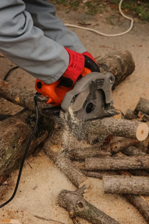 a person with a miter sawdusting a piece of tree wood