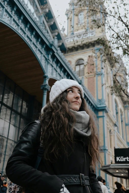 a young woman standing in front of a tall building