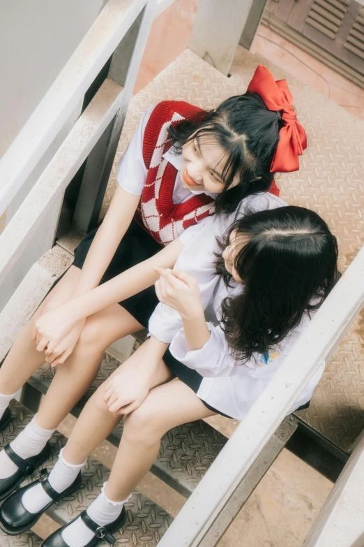 the two girls are sitting on a staircase together