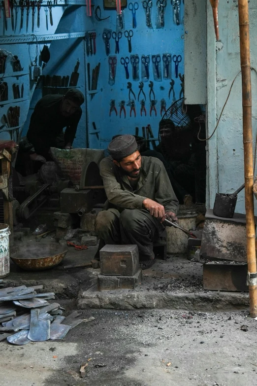 the man is sitting on the ground with his tools