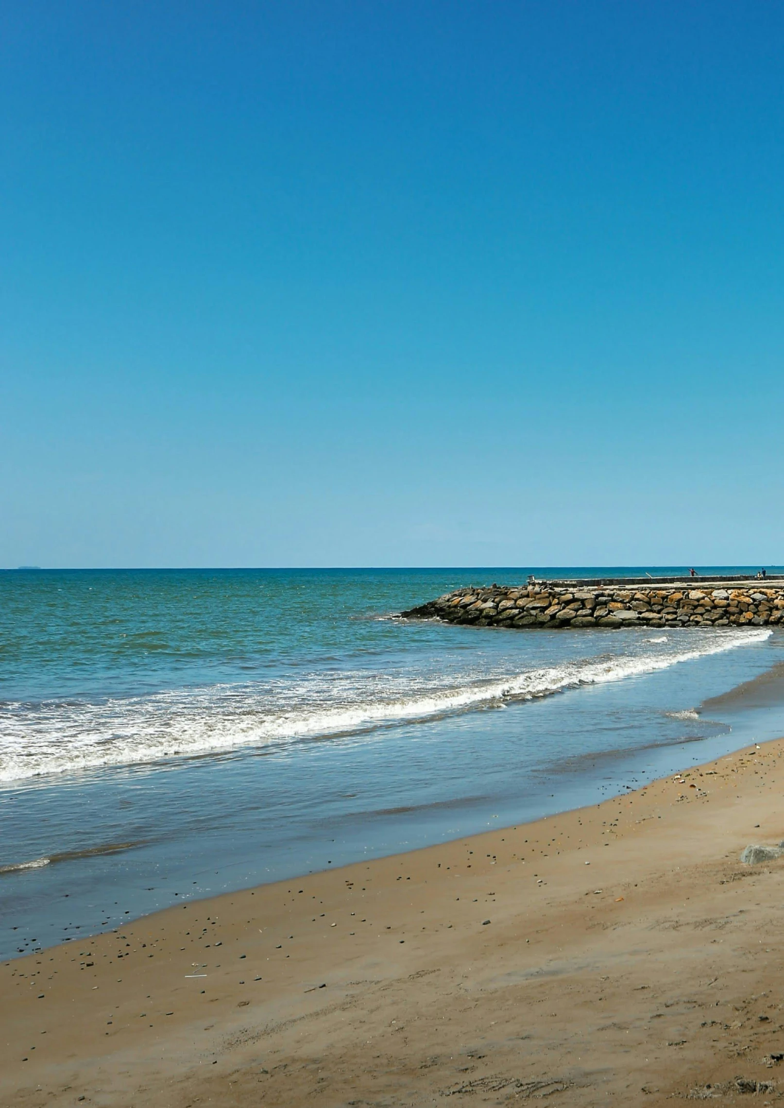 some water is sitting at the edge of a sandy beach