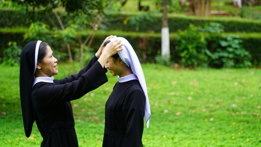 two young women dressed in black are touching each other's hands