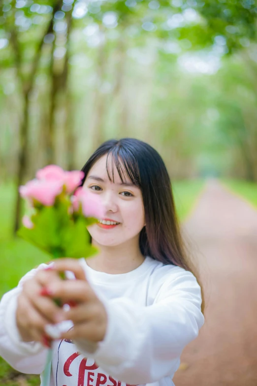 a woman holding flowers with both hands looking up