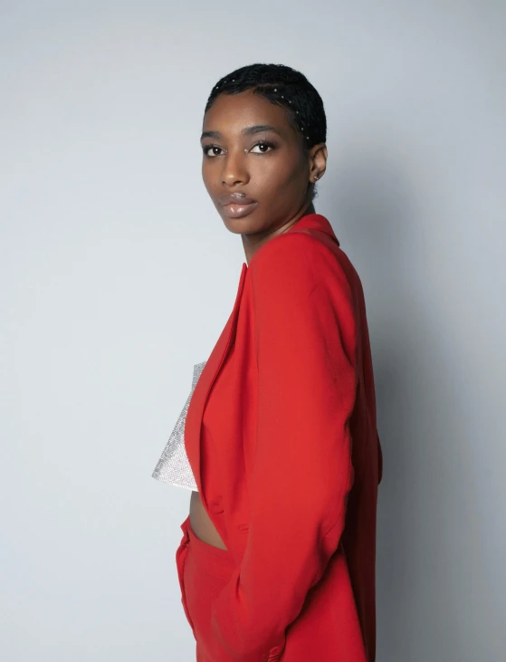 a woman posing in a red jacket with a white shirt on