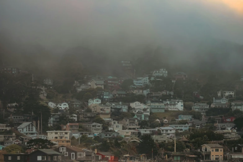 houses rise from the mountains as seen on a cloudy day