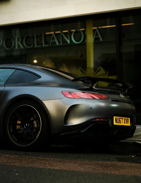 a mercedes sports car is parked in front of a business building