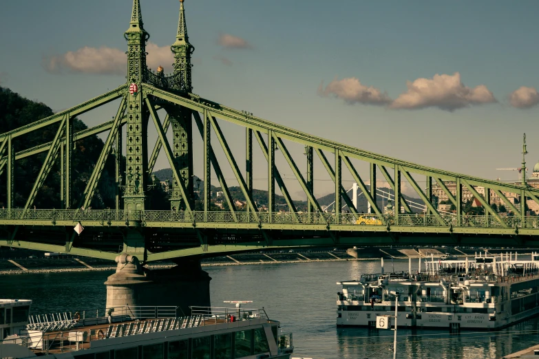 a large long green bridge spanning over a body of water