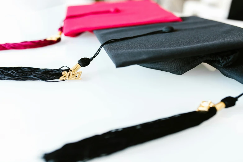 a black graduation cap, red book and red tassel