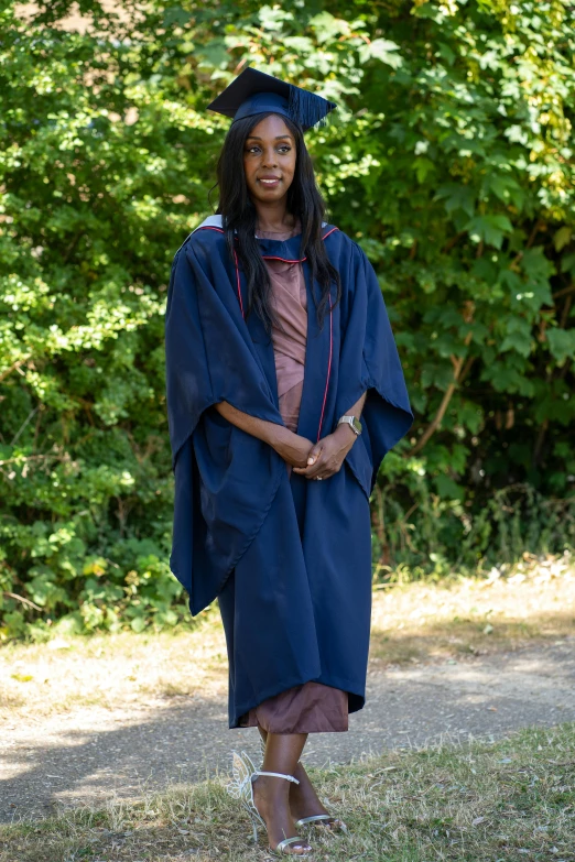 a young woman in graduation attire standing outside