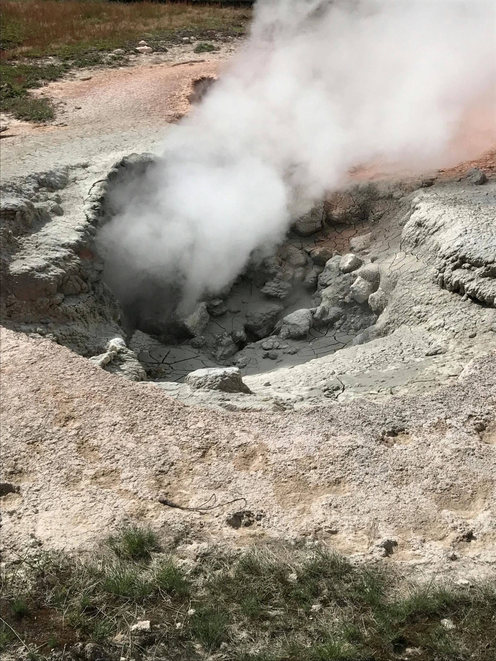 an old crater is surrounded by dirt and steam