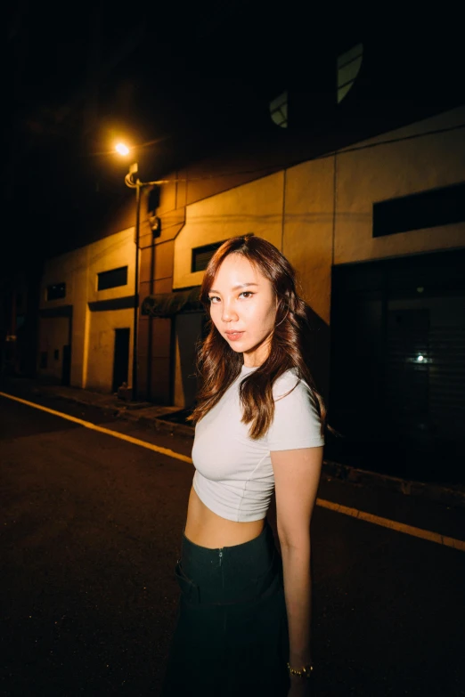 the girl is posing in the street at night