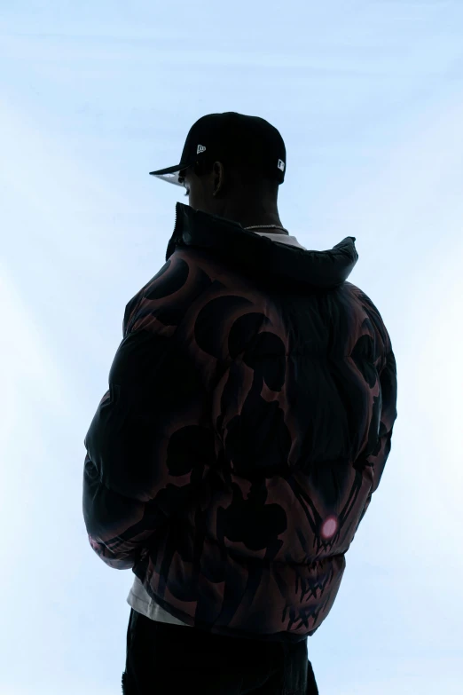 a person standing up with the hood of his jacket on