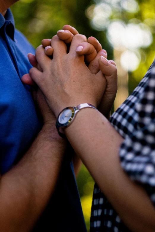 people holding hands together with trees in the background