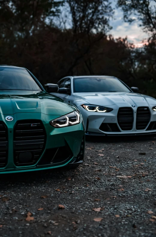 two cars parked in parking lot with trees in the background