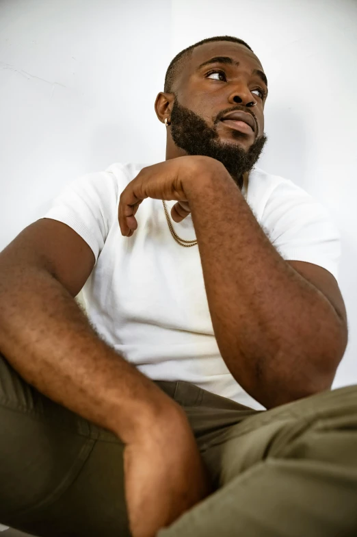 man wearing a white shirt and a green pair of pants