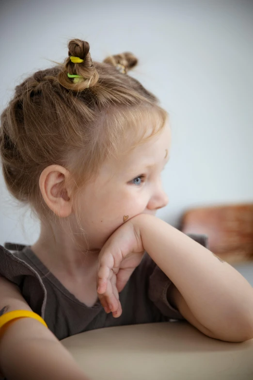 a  with blond hair sitting in a chair and looking away