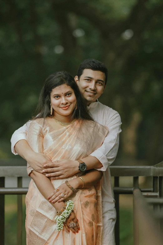 a woman in a sari holds her arms around a man