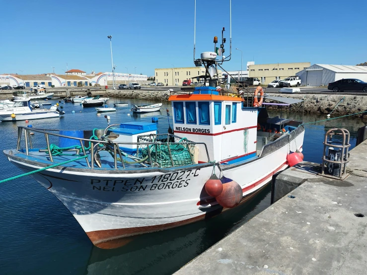 a fishing boat sits docked at the dock in a harbor