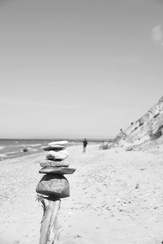 black and white pograph of a beach with a rock tower