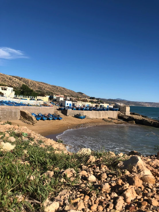 there are many small blue tents lined up on the beach