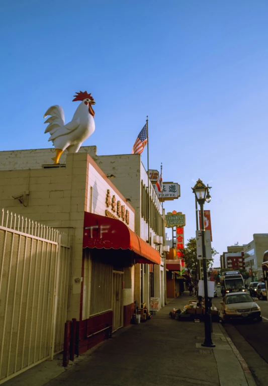 there is a big chicken on the top of this building