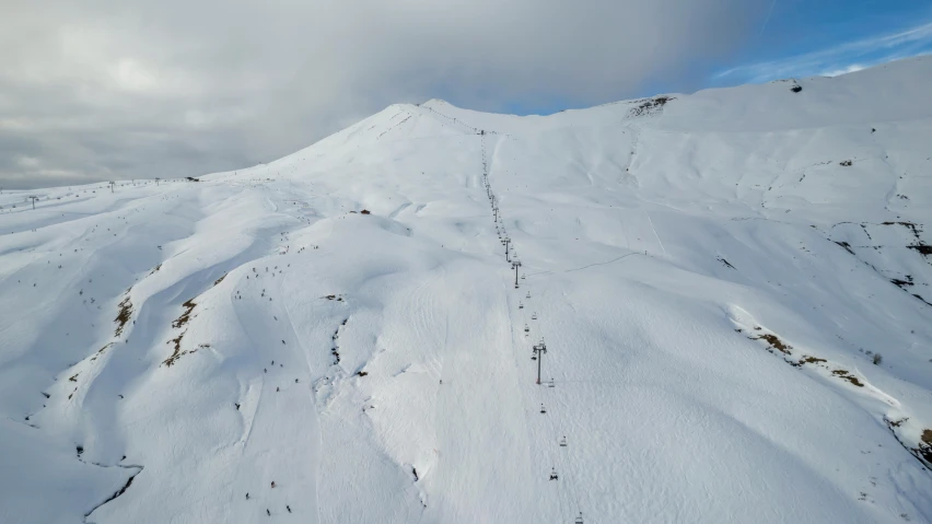 a mountain ski slope with some snow on top of it