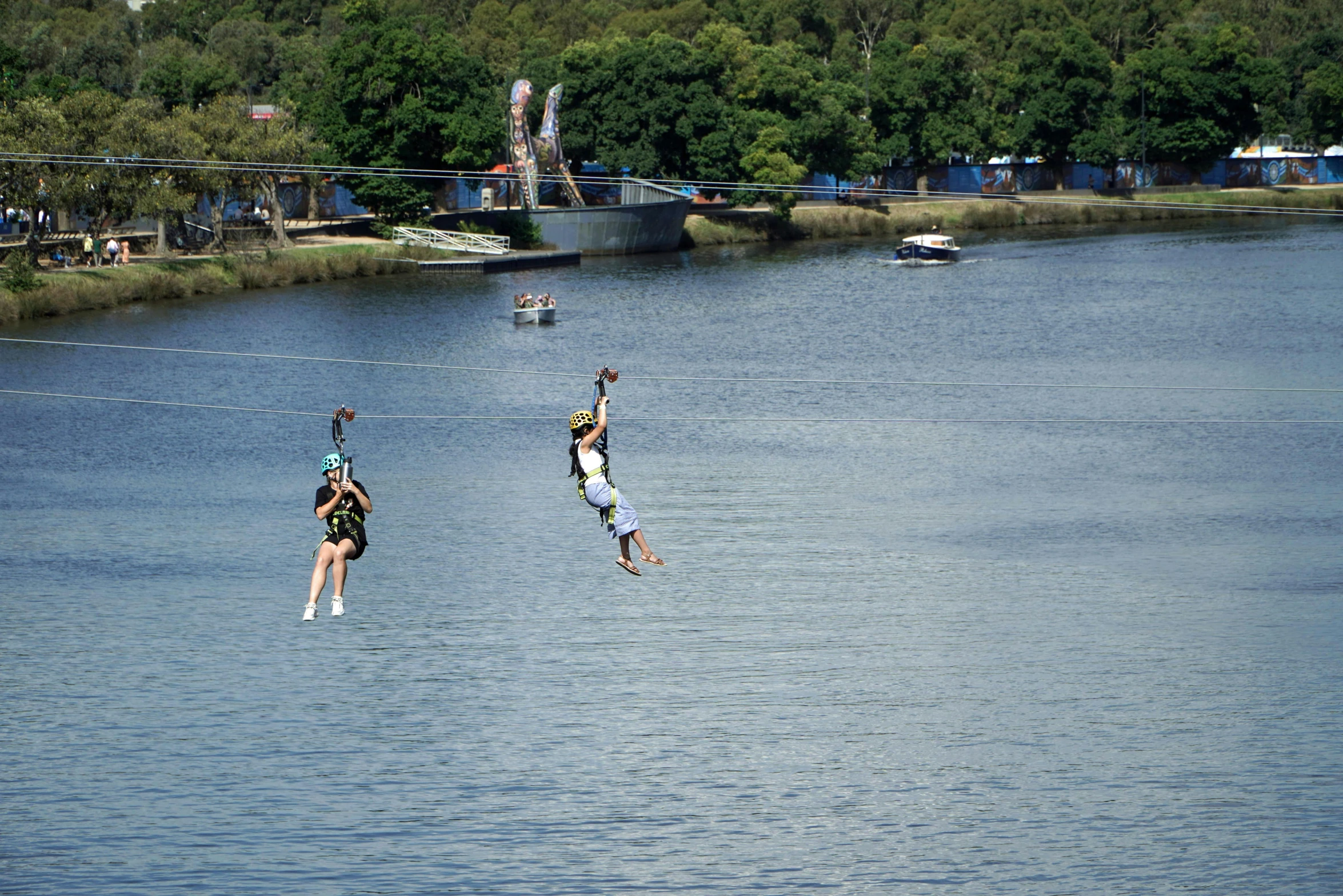 three people jumping in the water with a pair of parachutes