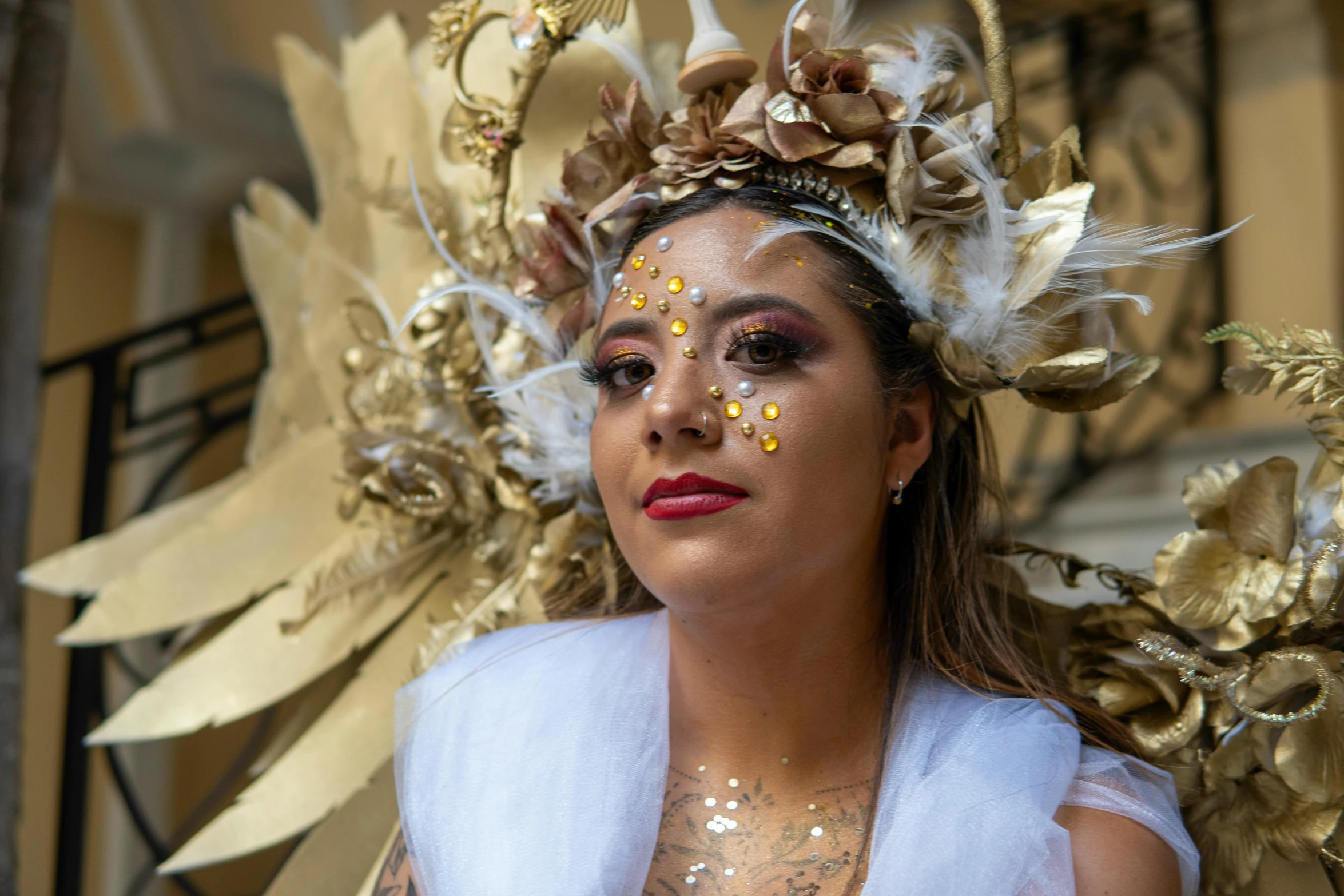 the lady is dressed in costume with feathers and flowers on her head