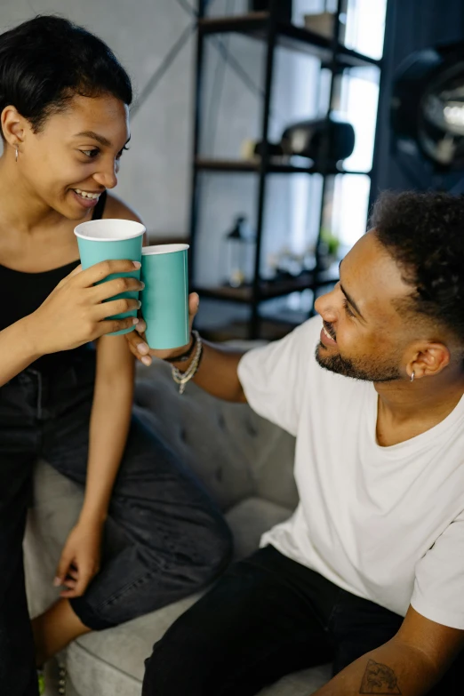 a woman holding a green cup with a man