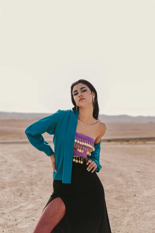 woman posing on beach in top layer clothing