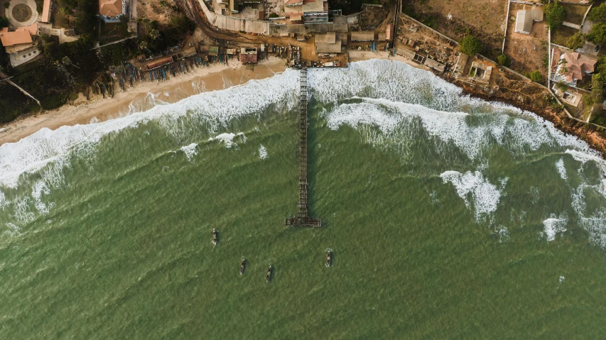 two people surfing on the beach in the water