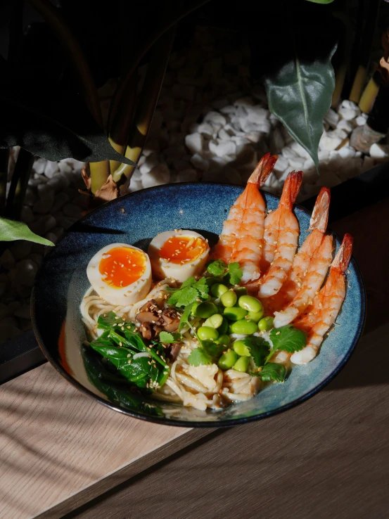 shrimp, rice noodles and vegetables in sauce with a wooden spoon