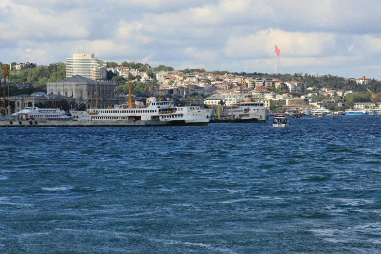 large boats are parked along the waterfront of a city