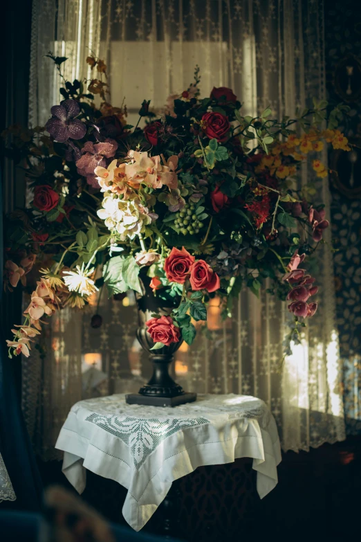 a vase of flowers on a table in front of a window