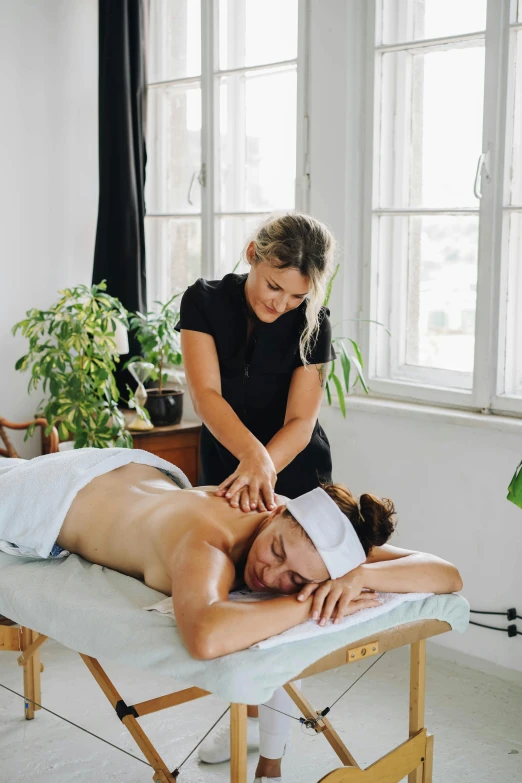 a man is having massages while another woman watches