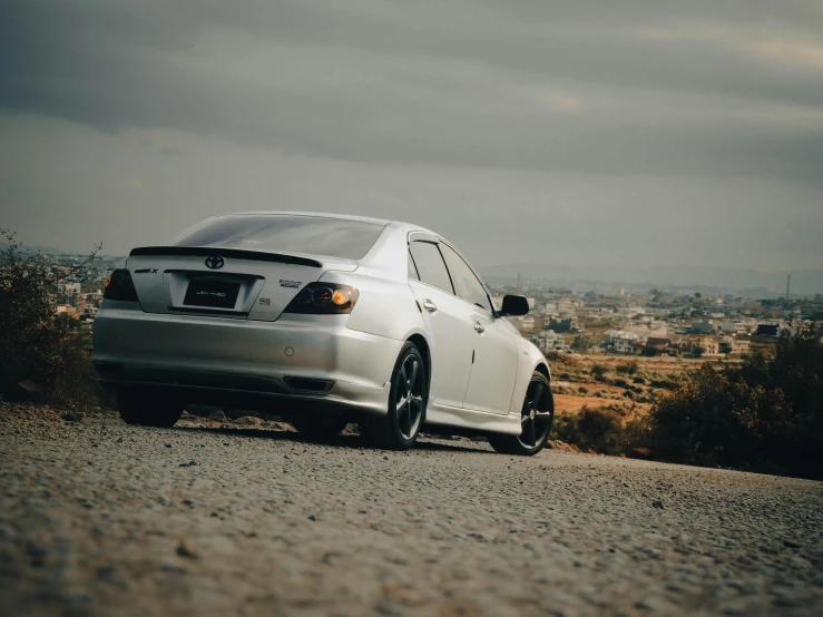 this car is parked on a gravel road