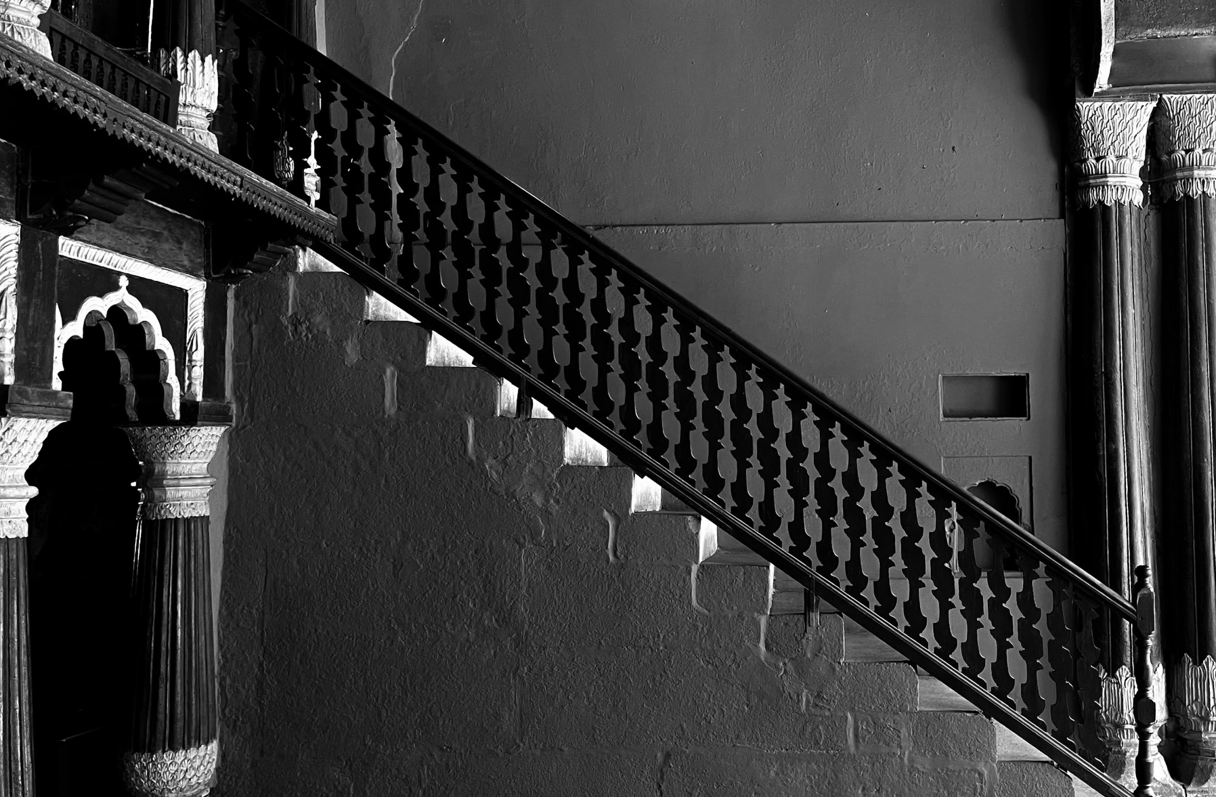 the stair case of an elegant mansion with ironwork