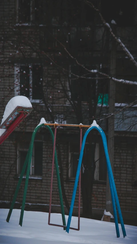 a playground swing that is covered in snow