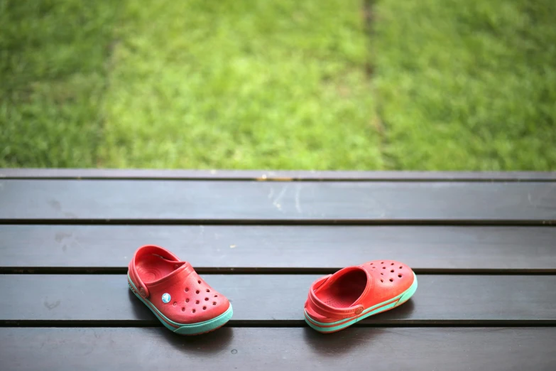 a couple of pairs of shoes sitting on top of a wooden bench