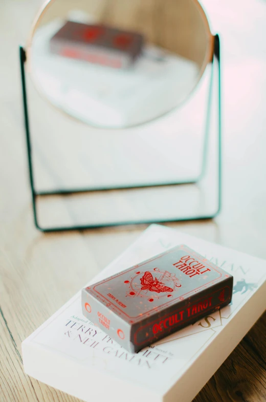 a red book sitting on top of a stack of books on a table