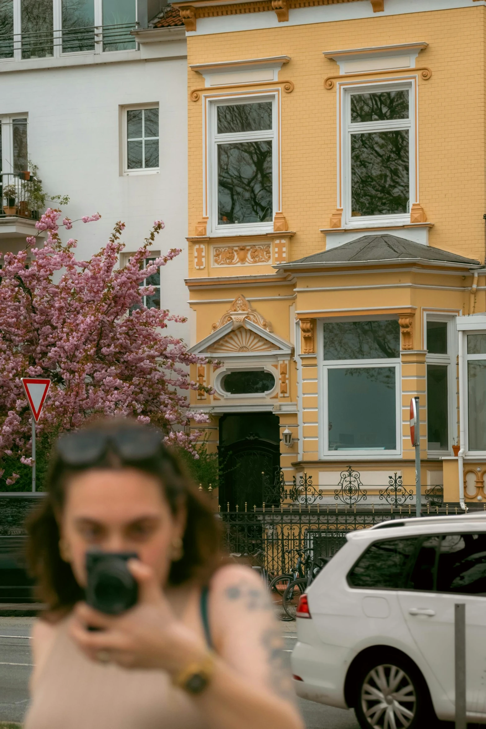 a woman in front of a building takes a picture