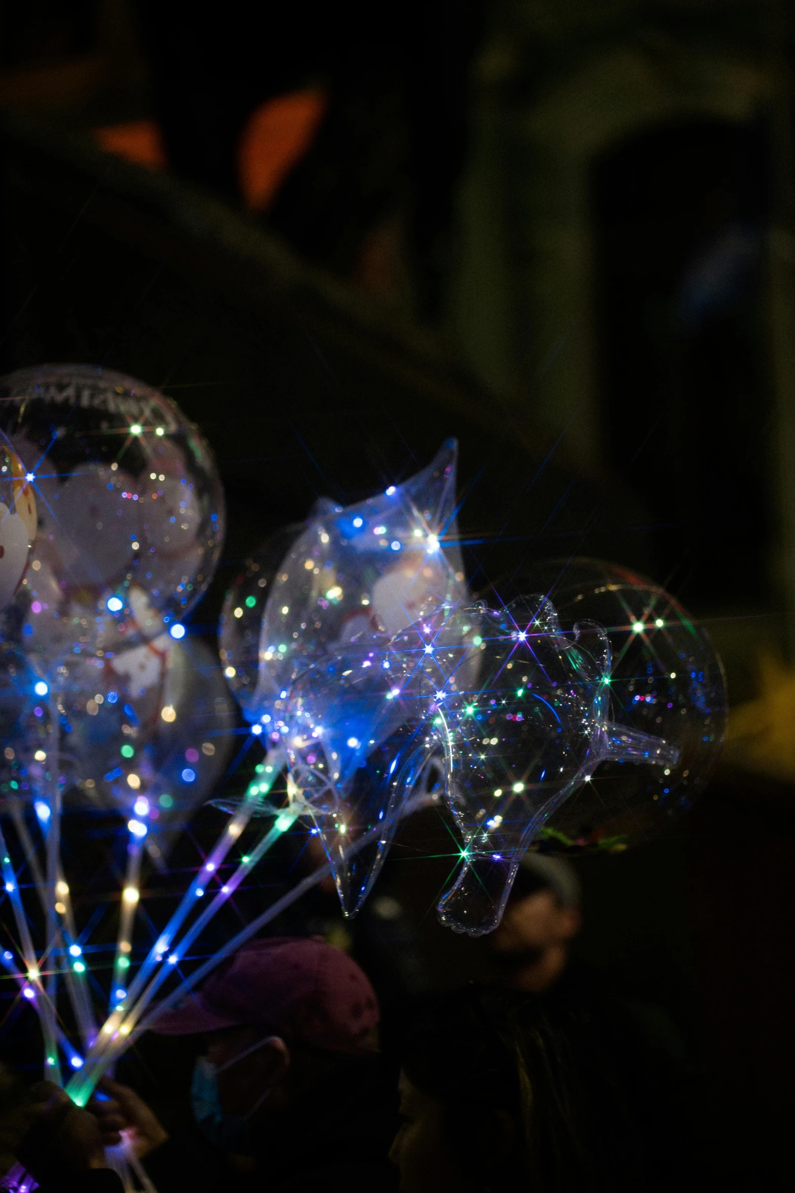 colorful lights attached to balloons on black background