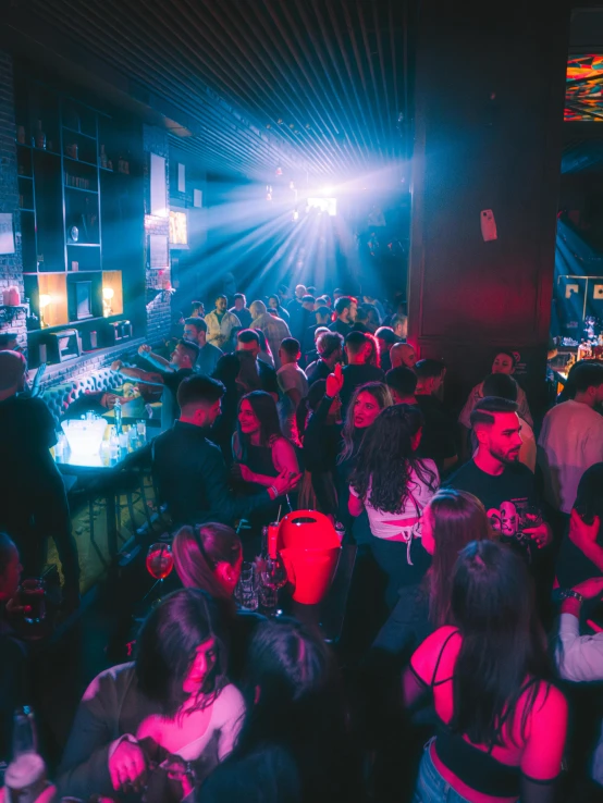 a crowded bar is full of people as the sun goes down