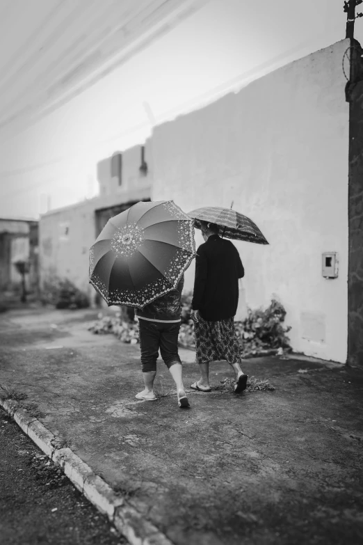 two people are standing under an umbrella outside