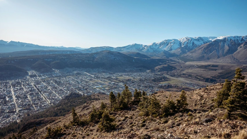 a valley filled with trees and snow covered mountains in the distance