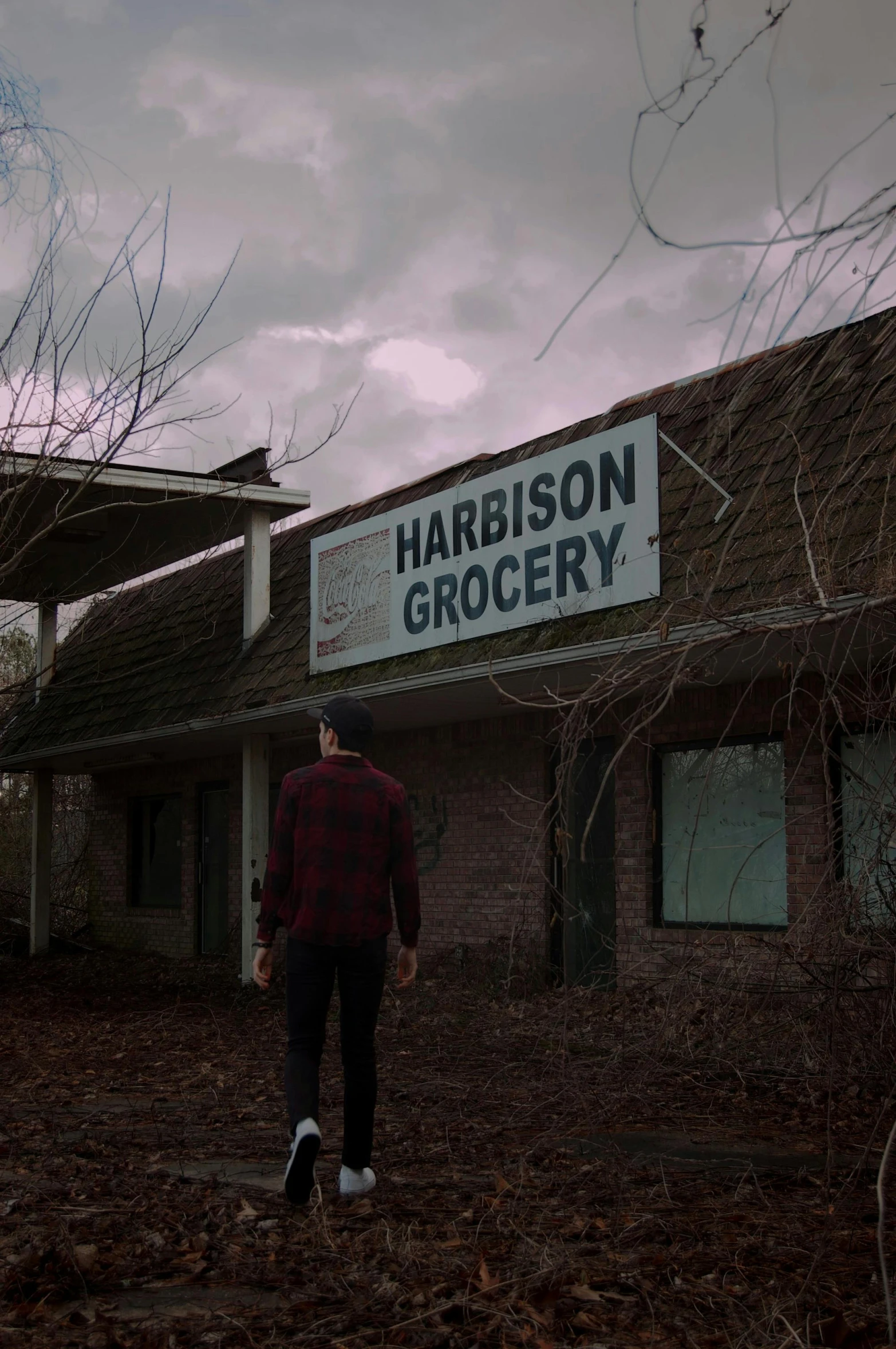 a man walking out from a building with sign that reads harrison grocery