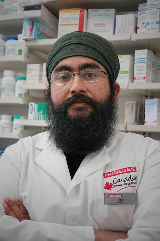 man with long beard wearing a white coat and green head scarf