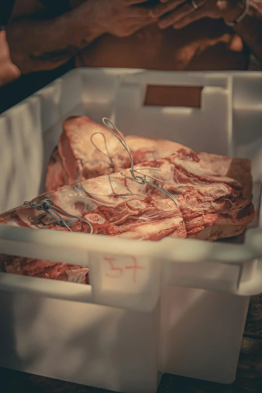 some raw meat sitting inside of a white container